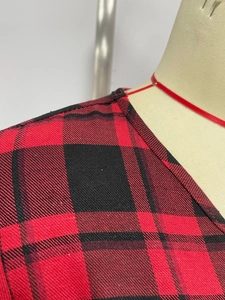 Detail of red and black plaid dress neckline with precise stitching and twill fabric