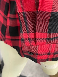 Detail of red and black plaid dress sleeve with button on durable twill fabric