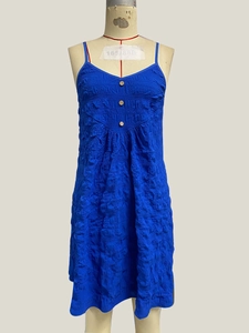 Detail of royal blue sundress showing textured fabric and three wooden buttons on the front