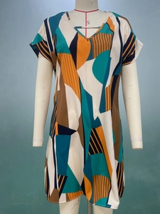 Dettaglio vestito a maniche corte con scollo a V, motivi geometrici e tessuto leggero