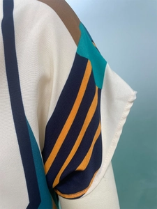 Dettaglio della stampa color block su manica e spalla di un abito estivo scollato