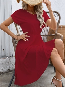 Detail of red short-sleeve A-line dress featuring high waist and pleated skirt texture