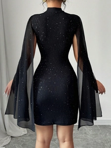Dettaglio dell'abito aderente nero con maniche in tulle spaccate e tessuto glitterato