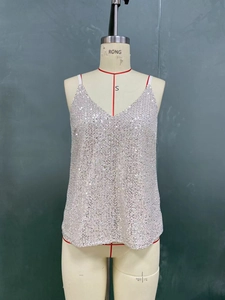 Detail of silver sequin tank top featuring a deep V-neck and delicate spaghetti straps