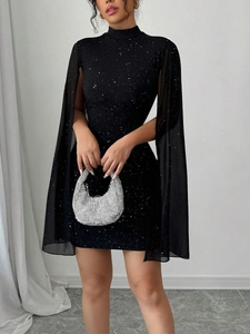 Dettaglio dell'abito corto nero elegante con paillettes scintillanti e maniche lunghe a mantella