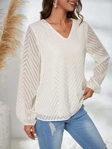 Détail du chemisier blanc semi-transparent à col en V avec un motif jacquard texturé chic