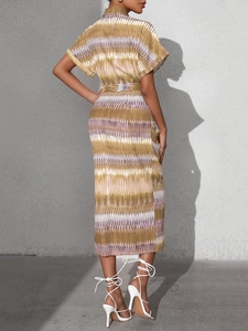 Back view of a bohemian geometric striped midi dress with waist tie and silhouette shadow