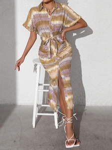Detail of printed shirt dress with waist tie and abstract geometric pattern in earthy tones