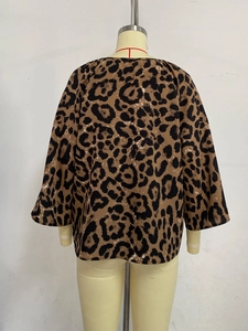 Back view of a leopard print blouse with a drop shoulder cut on a mannequin stand