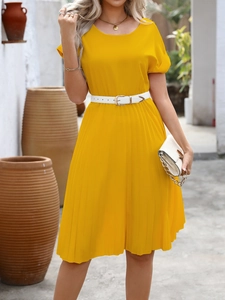 Detailed shot of yellow pleated A-line dress with white belt and bubble sleeves
