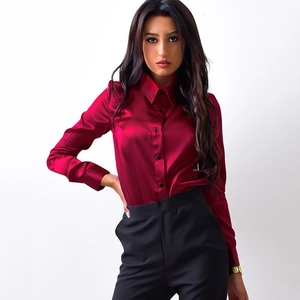 Close-up of wine red satin shirt featuring smooth glossy fabric and black round buttons