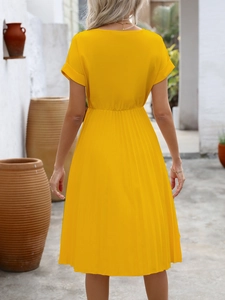 Detail of ginger yellow short sleeve dress with fine pleated hem and elastic waist