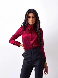 Detailed view of the dark red satin long sleeve shirt and black slim trousers