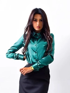 Detail of slim-fit emerald green satin shirt with classic collar and black buttons