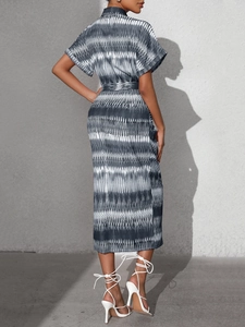 Back view of a midi dress featuring black and white wave prints with a waist tie detail