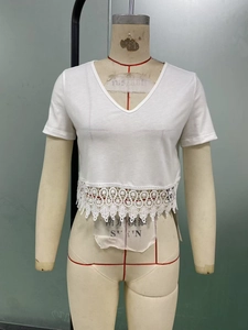 Close-up of white V-neck crop top featuring elegant wide crochet lace hem detailing