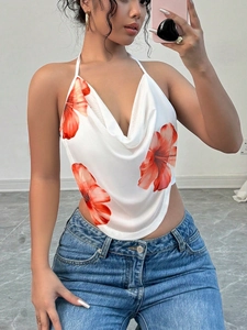 Detail of white satin cowl neck halter top with vibrant red floral print and draped fit