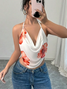 Detail of white halter neck top with orange hibiscus floral print and draped V-neckline