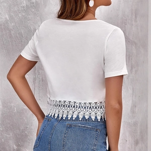 White V-neck crop top with delicate lace trim back view styled with denim jeans