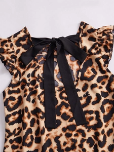 Detail of leopard print dress with a large black bow tie and ruffle sleeve accents