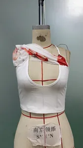 Detail of white crop top featuring deep U-cut neckline and red floral print on shoulder