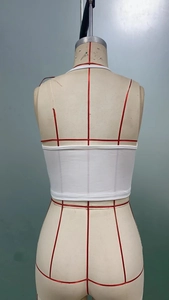 Detailed back view of a white cropped tank top with neat rolled hem stitching on a mannequin