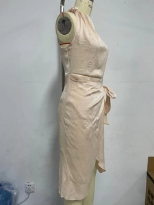 Detail eines Satin-Wickelkleides in Champagner mit Neckholder und verstellbarer Taille