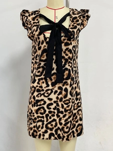 Detail of leopard print dress featuring black neck bow and ruffled flutter sleeves