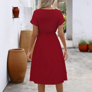 Women's burgundy short sleeve A-line dress with V-back and elastic waist in a scenic outdoor setting