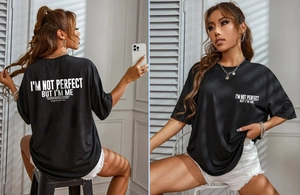 Detail of oversized black T-shirt featuring white inspirational text print on both sides