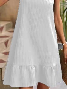 Close-up of white sleeveless A-line dress featuring vertical striped texture and ruffle hem