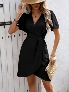 Detail of elegant black wrap dress with V-neckline and stylish ruched waist design