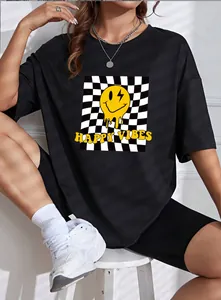 Detail of loose black t-shirt featuring melting smiley face and checkerboard pattern