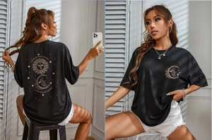 Detail of black oversized T-shirt featuring celestial sun and moon prints and text