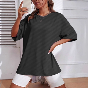 Detail shot of a black loose-fit crewneck T-shirt paired with white denim shorts
