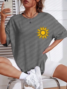 Dettaglio della T-shirt oversize grigia in cotone con stampa di girasole giallo sul petto