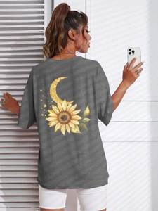 Dettaglio della stampa grafica con girasole e luna su t-shirt grigio scuro oversize