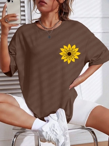 Detail of dark brown oversized t-shirt featuring a sunflower print on the chest