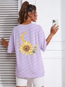 Dettaglio della t-shirt viola oversize con stampa artistica di girasole e luna sul retro