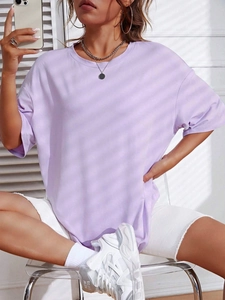 Dettaglio della maglietta oversize lavanda con scollo rotondo e spalle basse in cotone