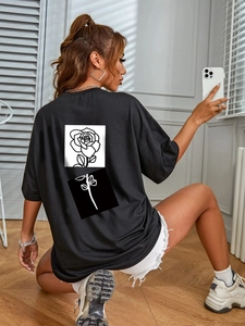 Women's black oversized cotton T-shirt featuring a minimalist rose graphic on the back
