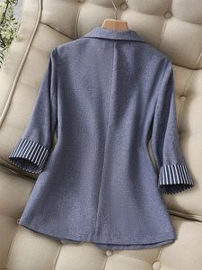 Detailed close-up of blue blazer featuring stylish striped cuff lining and textured fabric