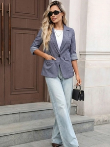 Detail of three-quarter sleeves with striped lining on a blue-grey blazer jacket