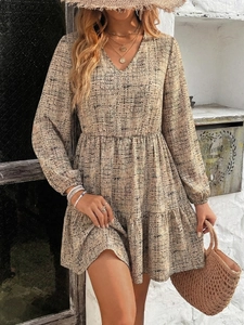 Close-up of bohemian V-neck long sleeve dress with abstract print and ruffle details