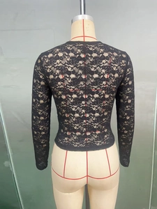 Détails de la couture arrière et de la texture en dentelle florale de ce haut noir cintré