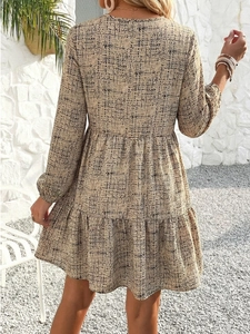 Detail view showing tiered layers of a beige mini dress with black dot pattern