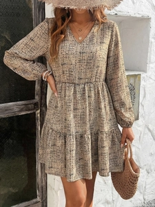 Close-up of V-neck printed dress with elastic high waist and ruffled A-line hem detail