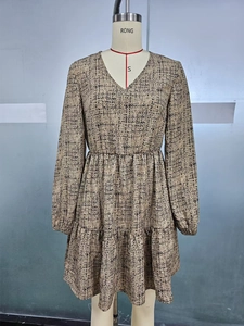Detail of V-neck long sleeve dress featuring abstract print and tiered ruffle skirt