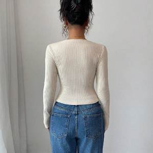 Slim fit cream long sleeve knit top with ribbed texture paired with classic denim jeans