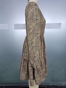 Detail of elegant long-sleeve dress with khaki floral print and tiered A-line skirt